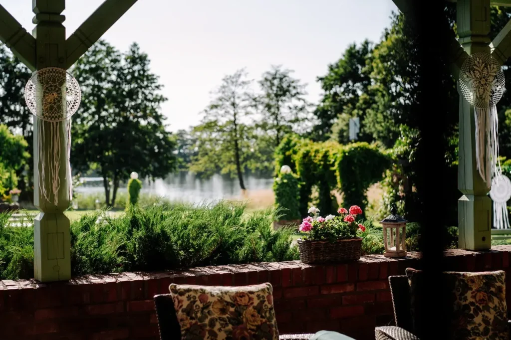 Widok z tarasu przy sali weselnej na ogród i jezioro