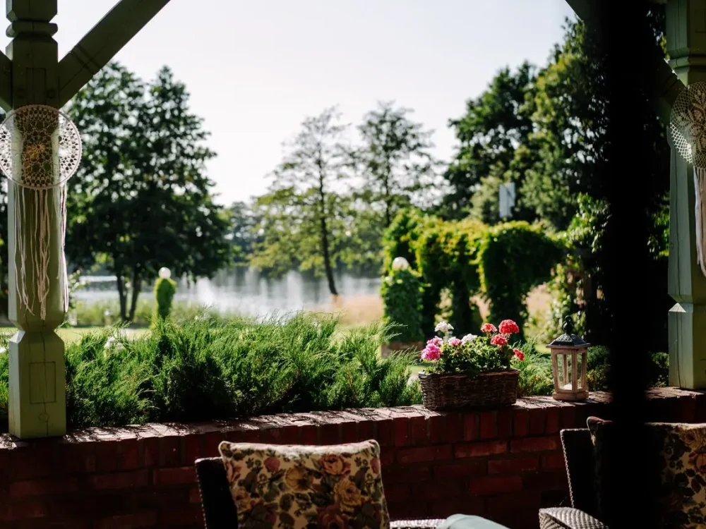 Widok z tarasu przy sali weselnej na ogród i jezioro